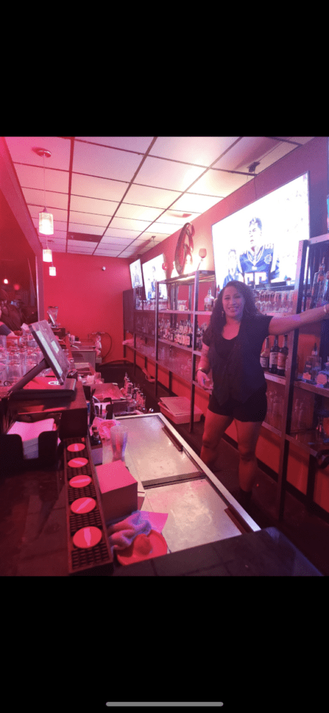 A woman at the bar wearing a black dress